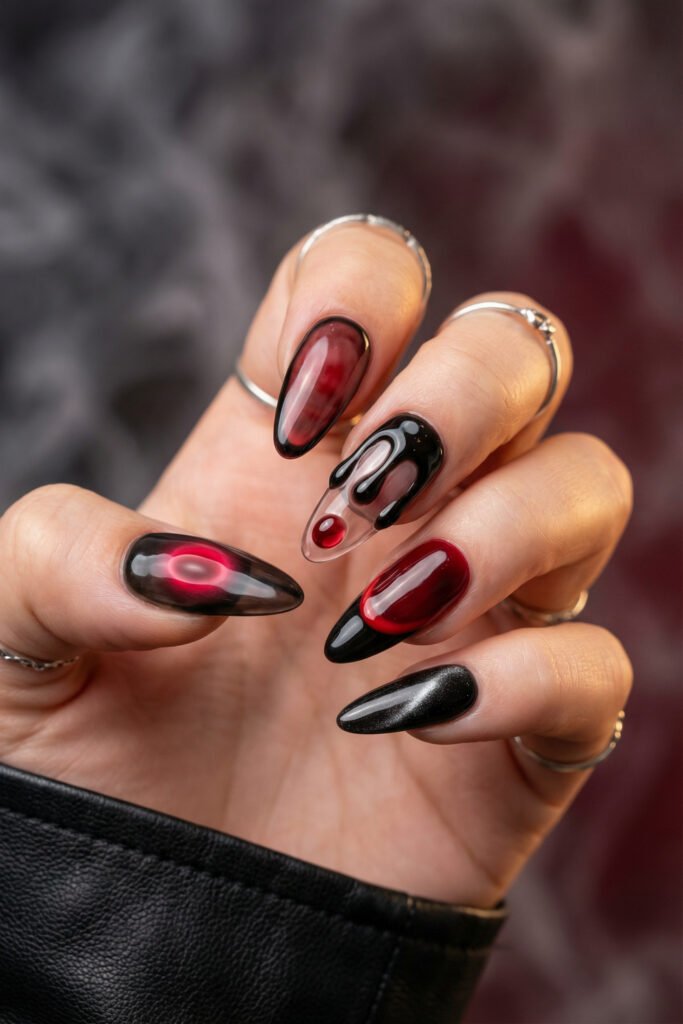 Black and Red Nails for a Bold, Polished Look 3 Hand with silver rings showing glossy black and deep red almond nails with smoky gradients and a clear accent nail featuring a black drip design