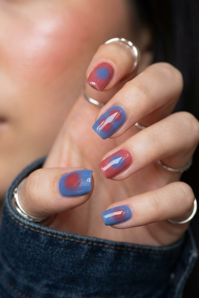 Short square blue and red nails with soft aura centers, glossy jelly finish, and denim sleeve for a modern minimalist look
