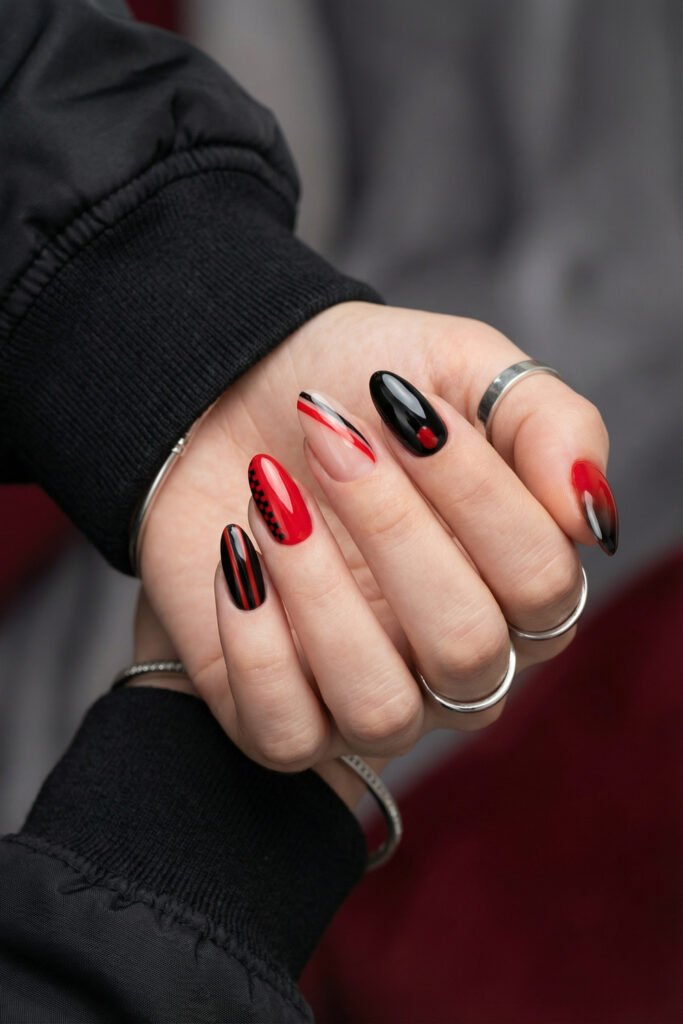 Black and Red Nails for a Bold, Polished Look 14 Hand with silver rings showing red black and nude almond nails featuring sleek stripes a checker accent and glossy ombre tips
