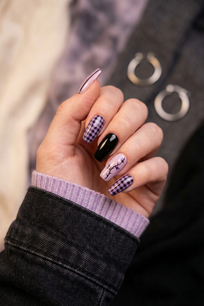 Lavender plaid, glossy black, and floral branch nail art on coffin nails give this spring goth nails set a playful yet moody finish.

