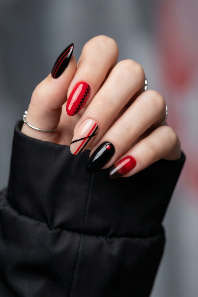 Black and Red Nails for a Bold, Polished Look 15 Close up of red black and nude almond nails with graphic stripes a checker accent a red dot detail and a smoky gradient tip