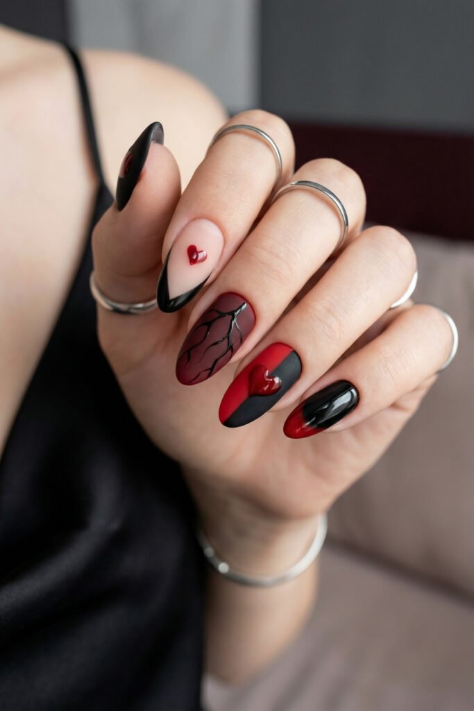 Black and Red Nails for a Bold, Polished Look 17 Close up of matte and glossy almond nails in black red and nude with heart accents a vein design and black French tips